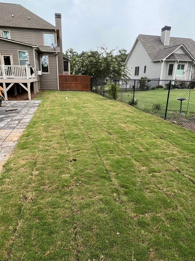 A large lush green lawn in front of a house.