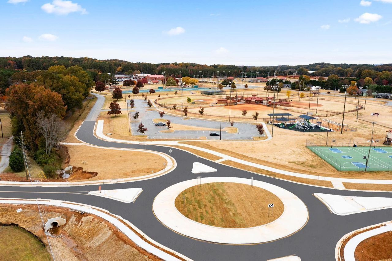 An aerial view of a roundabout with a playground in the background