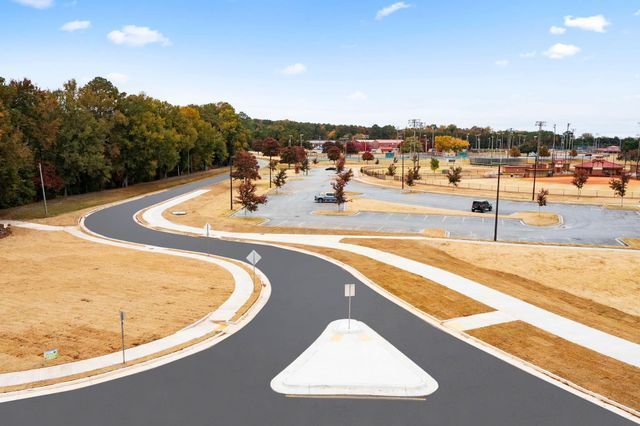 An aerial view of a road with a white arrow pointing to the right.