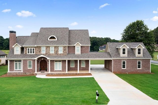 A large brick house with a driveway leading to it