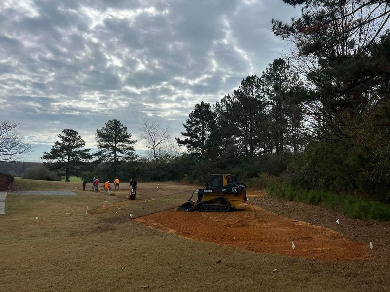 A bulldozer is sitting in the middle of a grassy field.