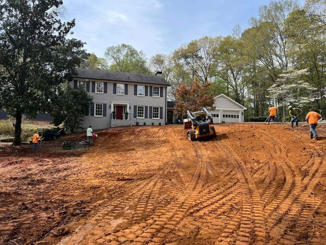 A bulldozer is moving dirt in front of a house.