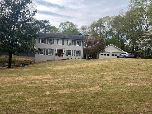 A large house with a large lawn in front of it.