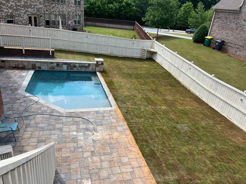 There is a swimming pool in the backyard of a house.