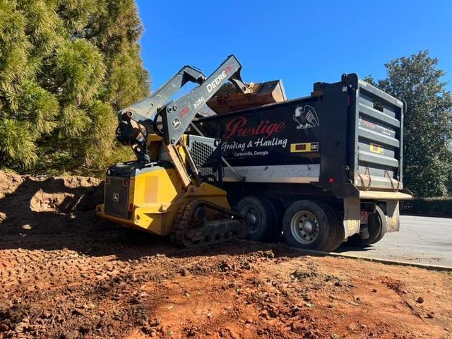 A dump truck is being loaded with dirt by a bulldozer.