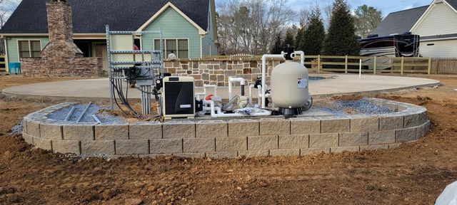 A swimming pool is being built in the backyard of a house.