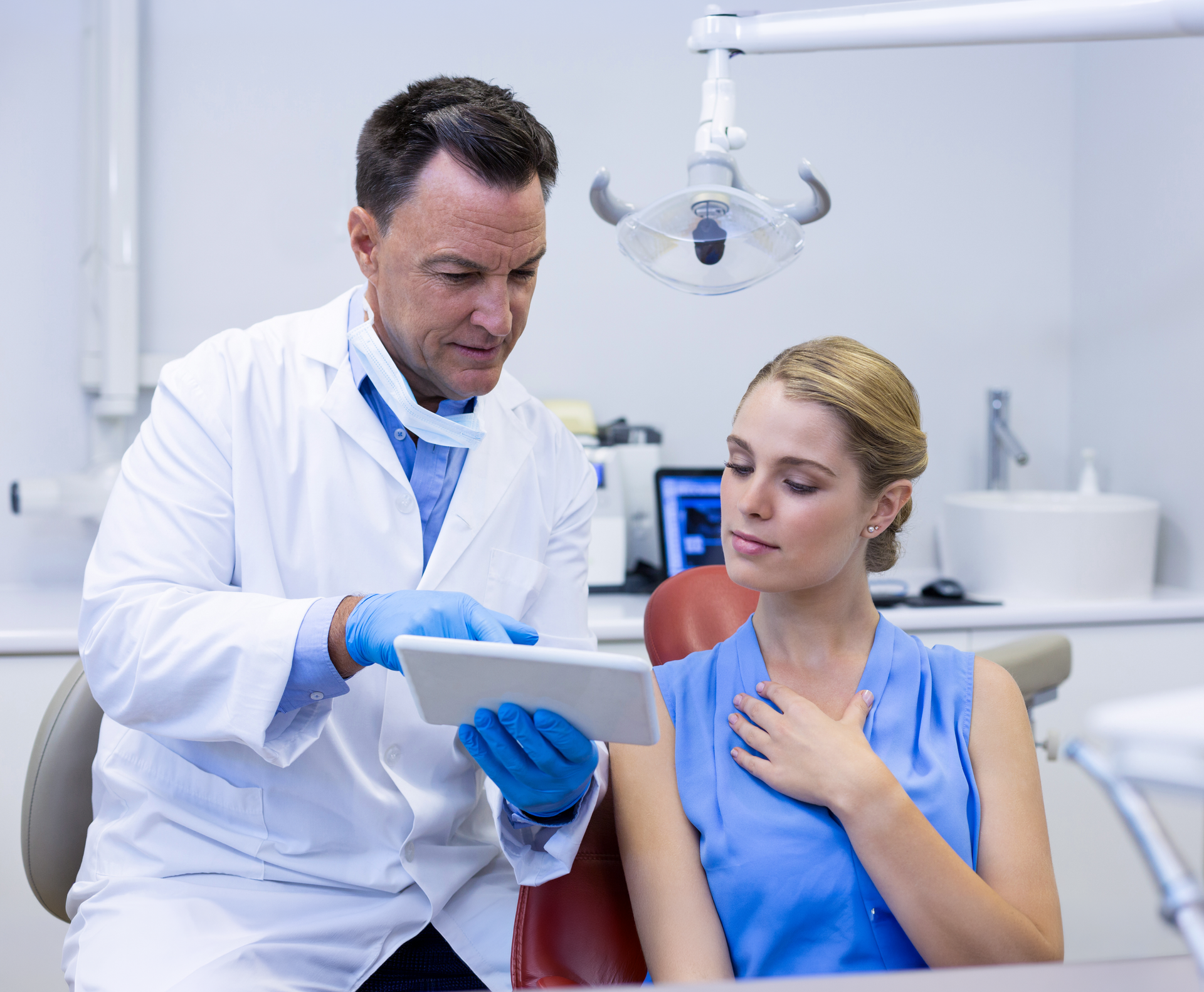 A woman in a bathrobe is sitting in a chair with a syringe in her arm.