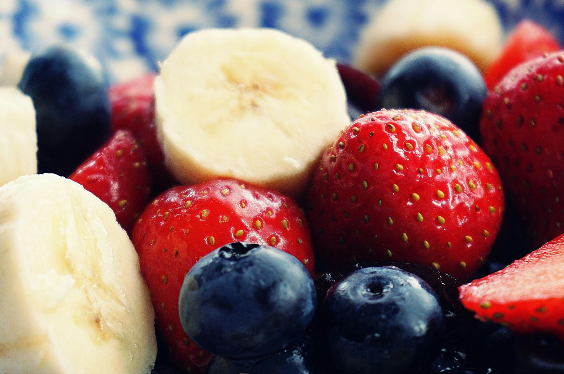 Strawberries blueberries bananas and watermelon are in a bowl