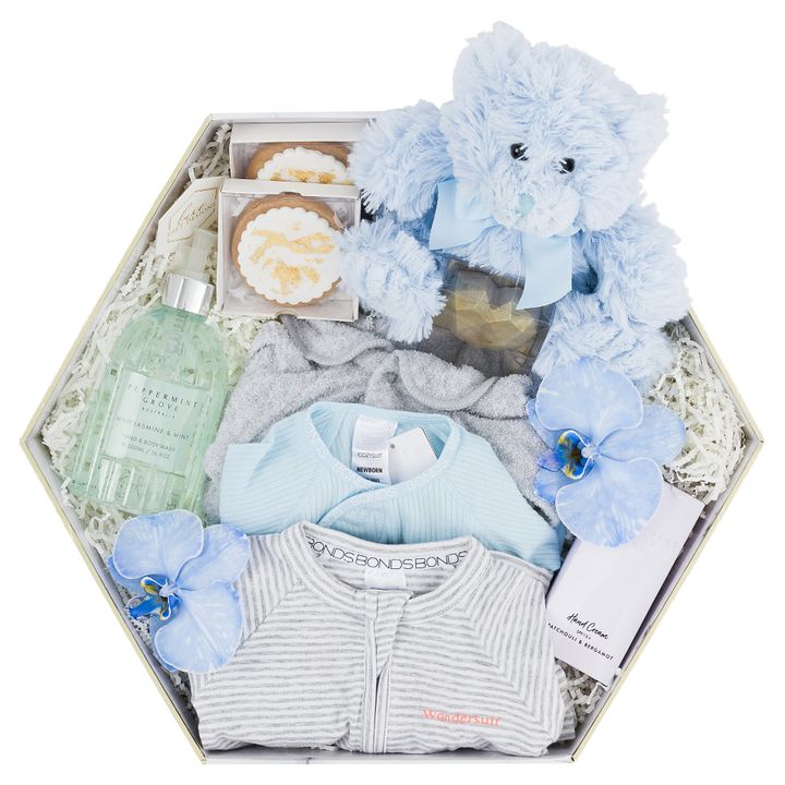 white box with baby boy clothes, hand and bodywash and soap, hand cream and blue bear