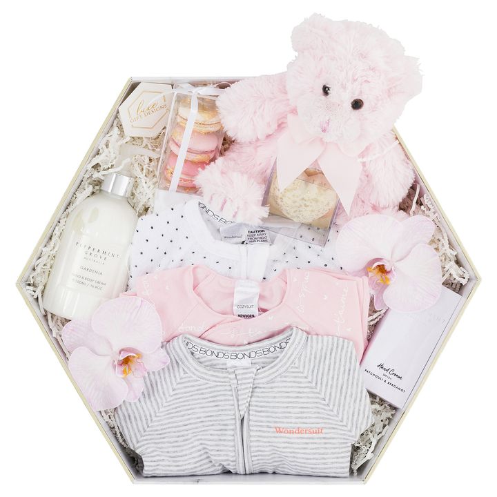 white box with baby girl clothes, hand and bodywash and soap, hand cream and blue bear