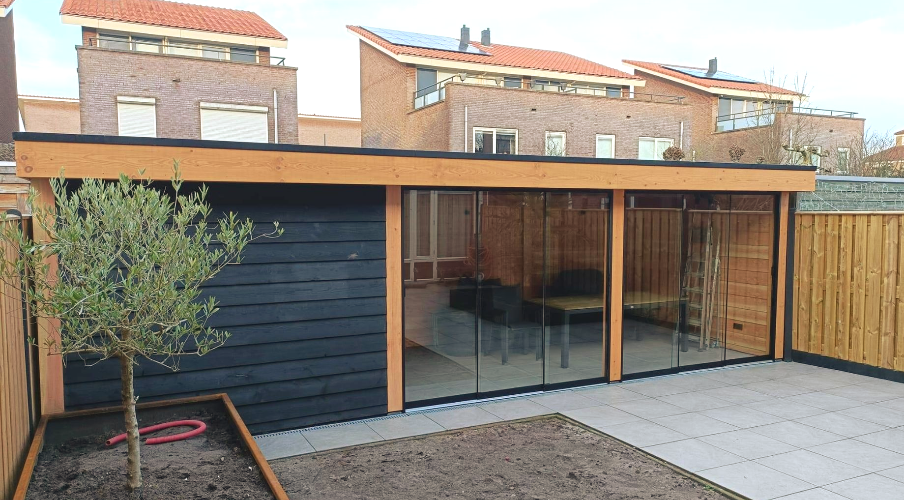 Glazen schuifwanden in Elst – Tuinkamer onder overkapping | VerandaGo