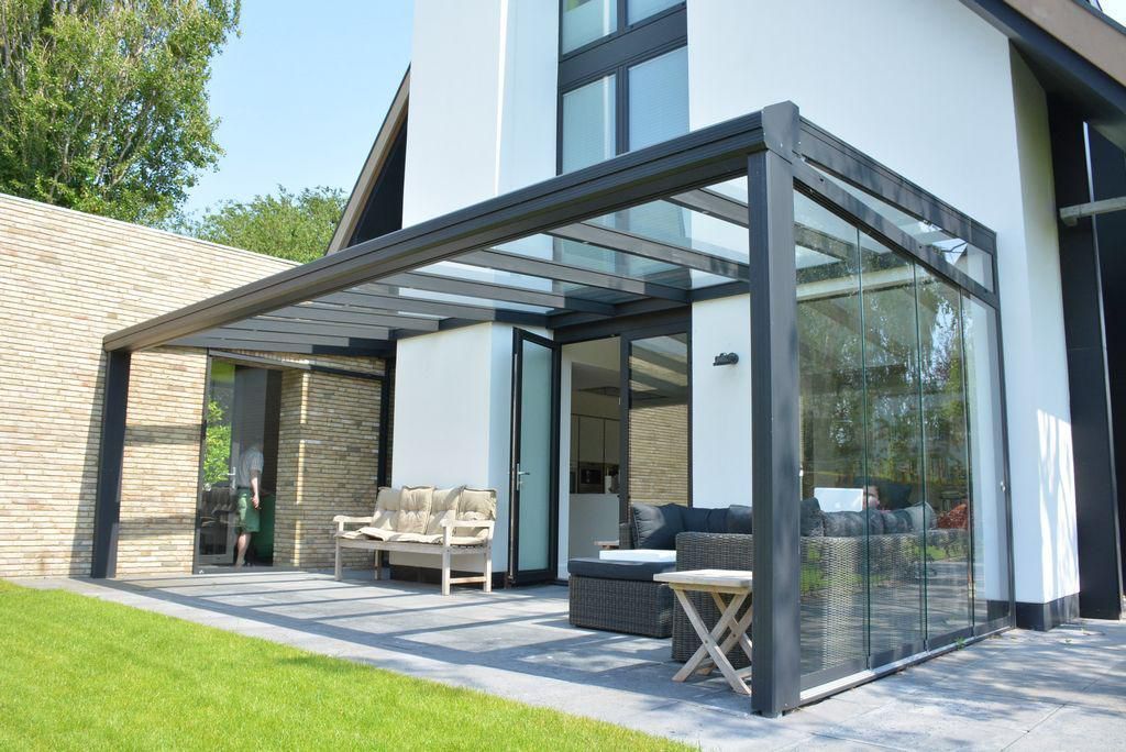 Een huis met een overdekte patio met een glazen dak