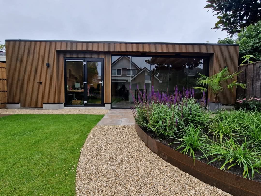 Een huis met veel ramen en een looppad ernaartoe.