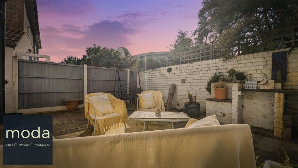 Backyard patio with seating at dusk.
