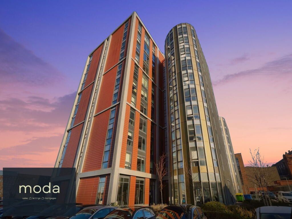 Moda apartment buildings in Manchester at sunset. Red brick and reflective glass skyscrapers.