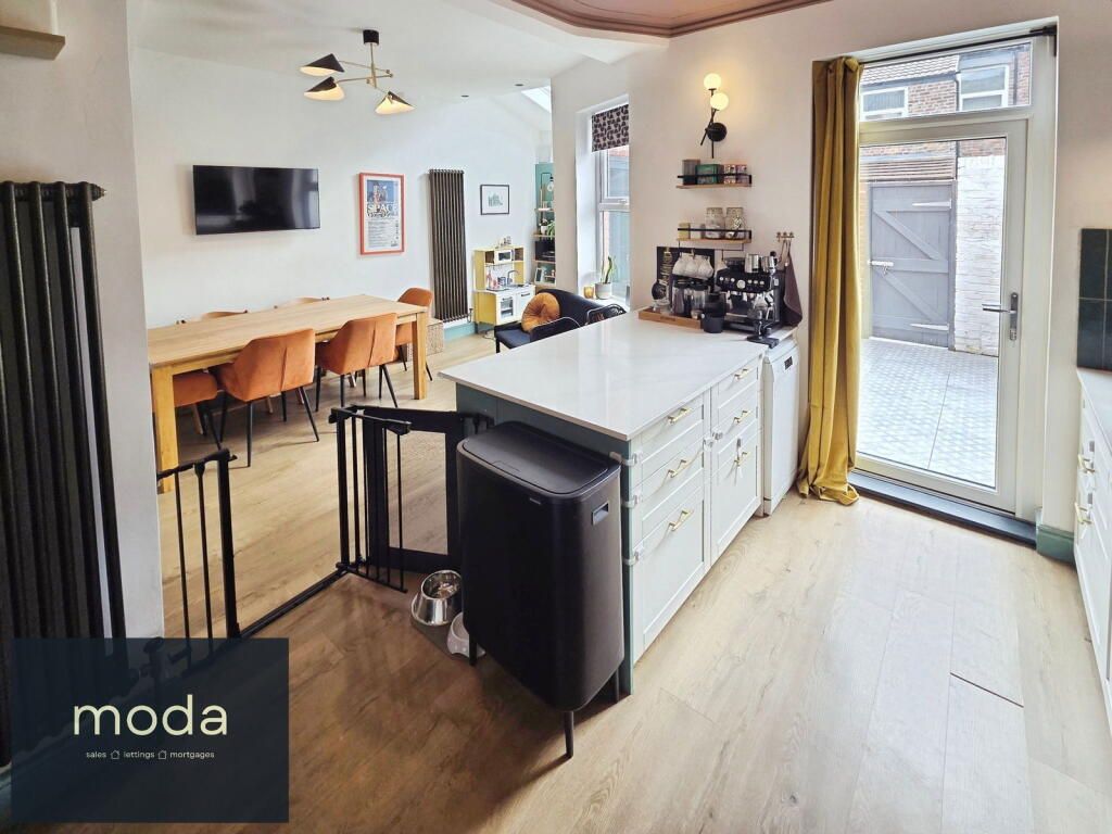 Modern kitchen with island, dining area, and access to the backyard.