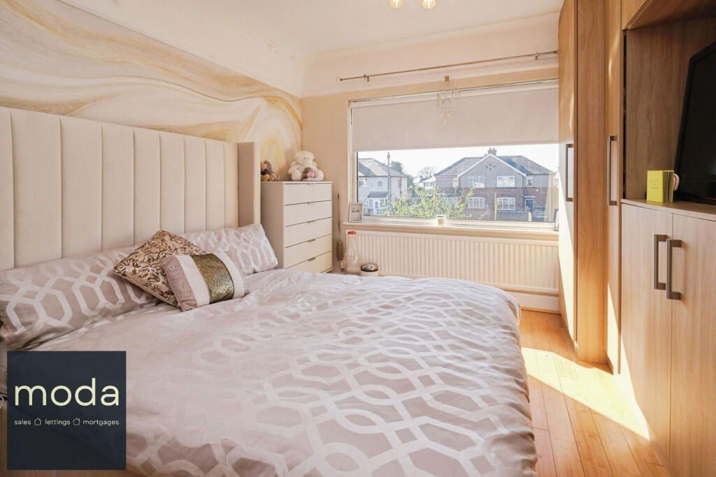 Bedroom with a large bed, tall headboard, large window, and built-in cabinets.
