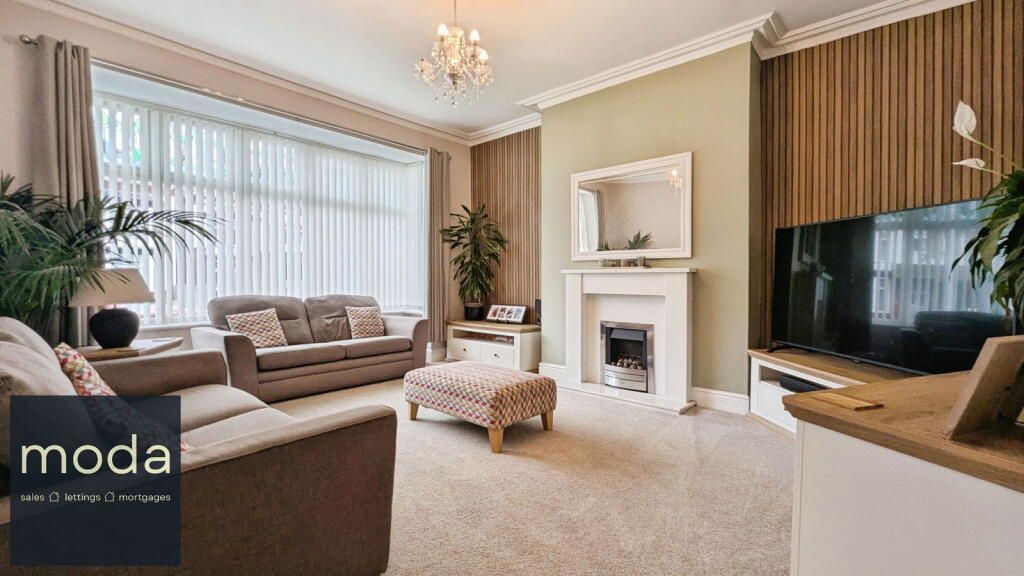 Living room with a sofa, fireplace, TV, and neutral-toned walls.