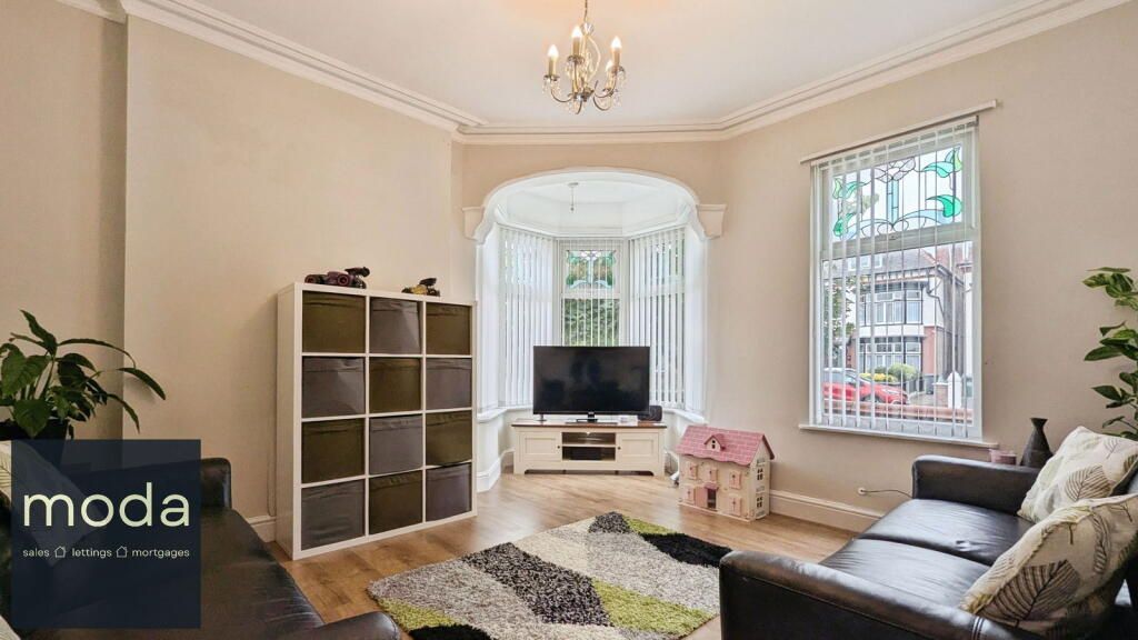 Living room with a television in a bay window, couch, storage cubes, and rug.