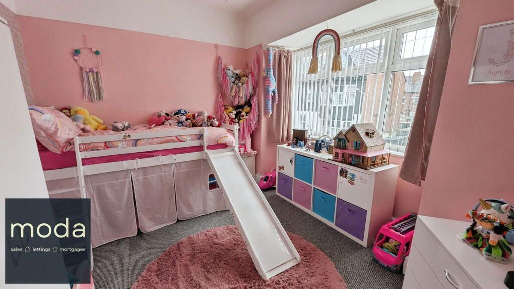 Pink bedroom with a loft bed, slide, toys, and window with a rainbow decor.