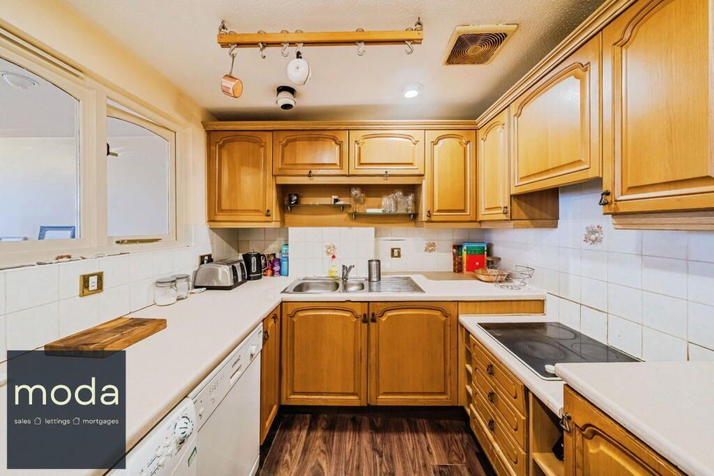Wooden kitchen with cabinets, countertop, and appliances.