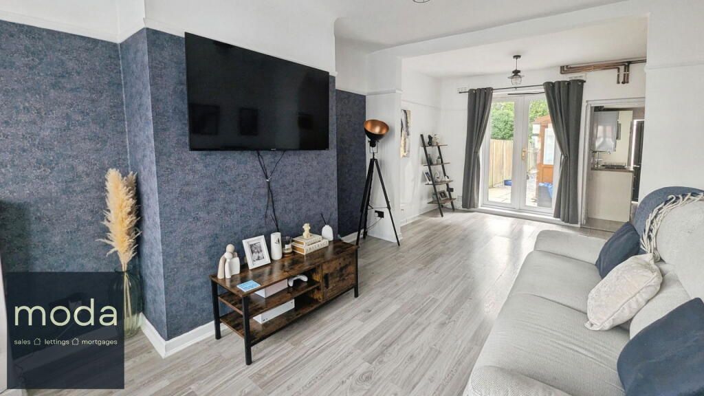 Living room with blue textured wall, TV, sofa, and access to the backyard.