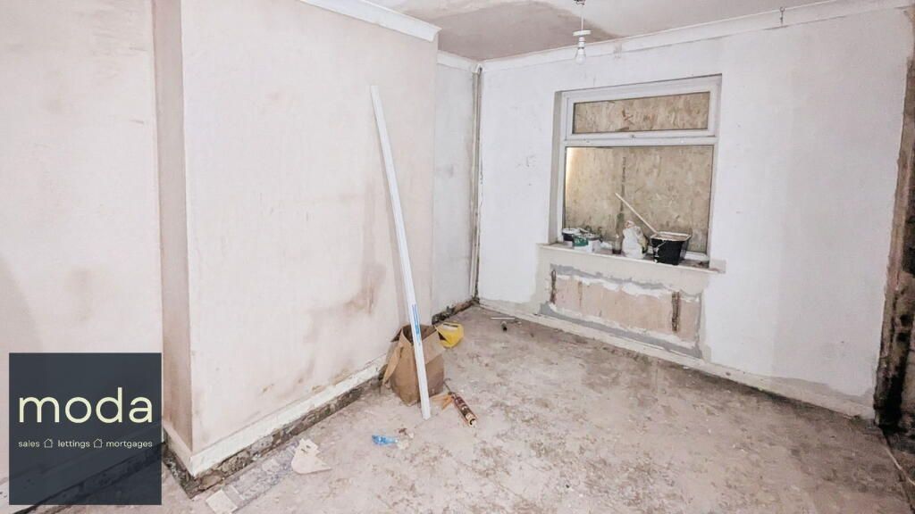 Room renovation: unfinished walls, window, debris on the floor, plaster, and a white stick.