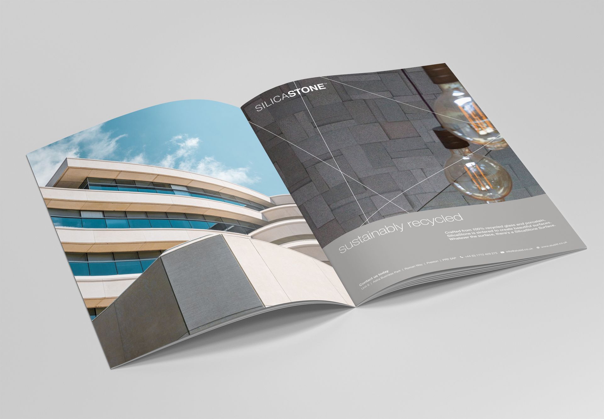 Open magazine displaying modern building photos on a light gray background