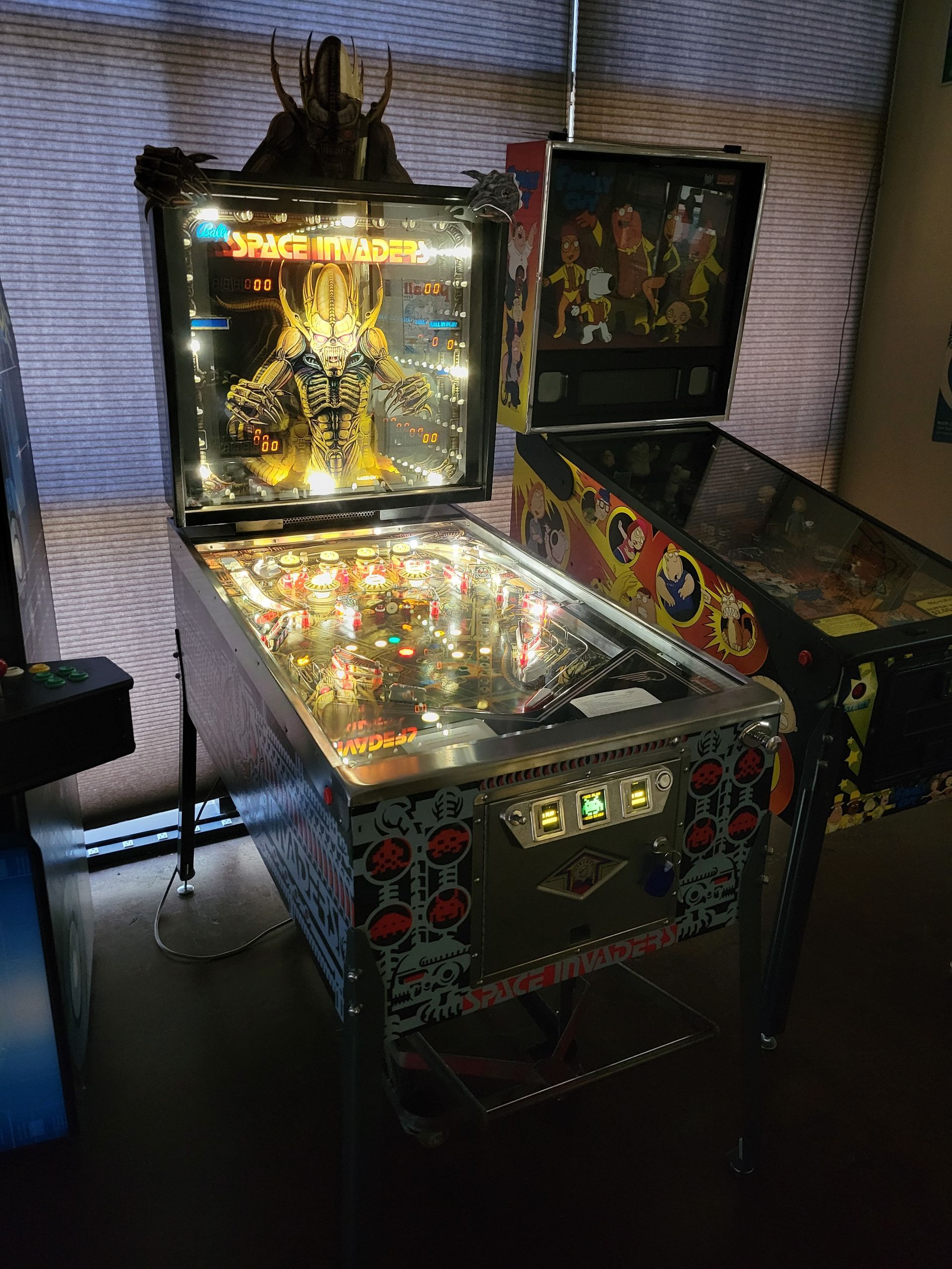 A pinball machine is sitting on a table next to another pinball machine.