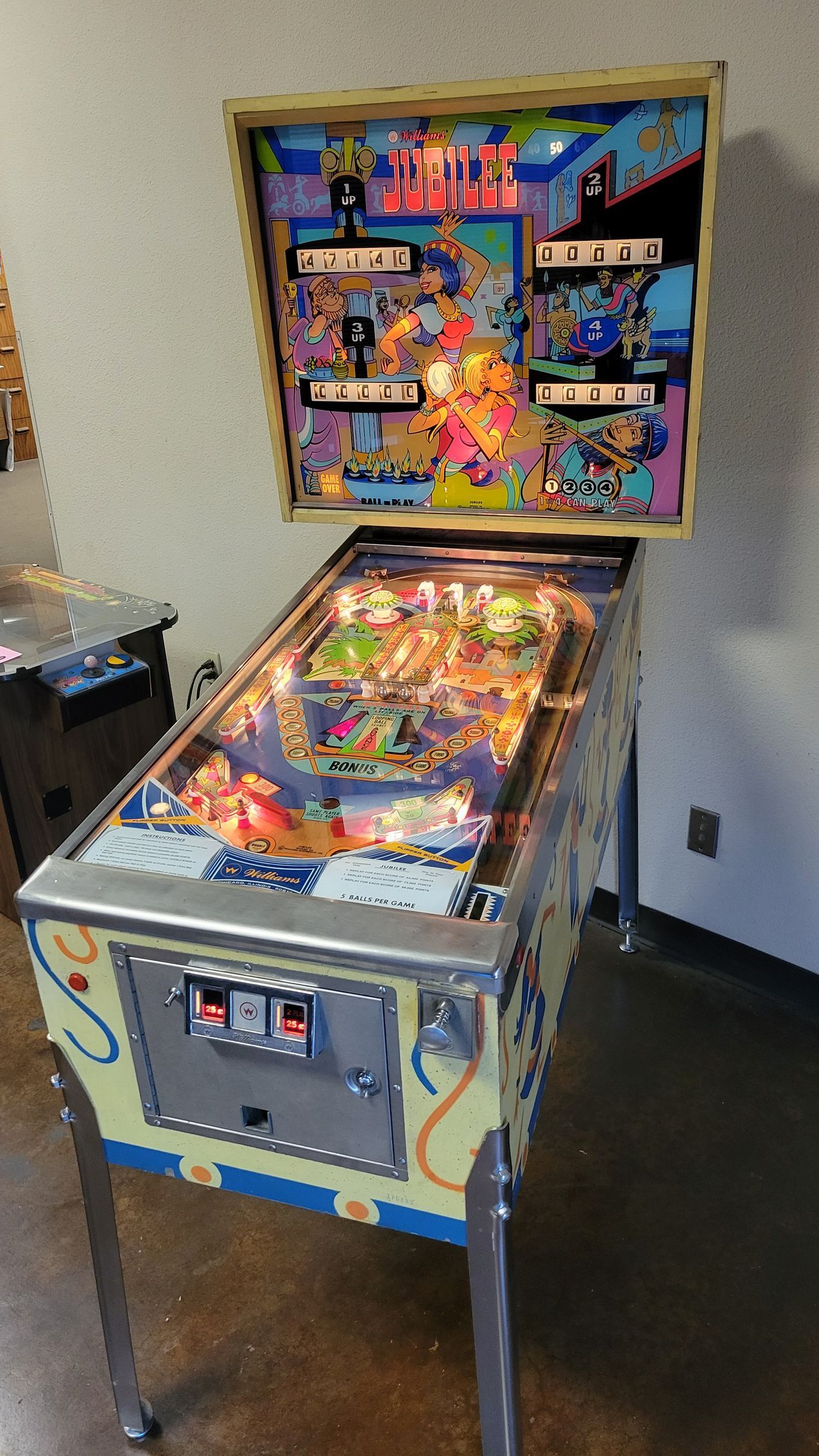 A pinball machine is sitting on a table in a room.