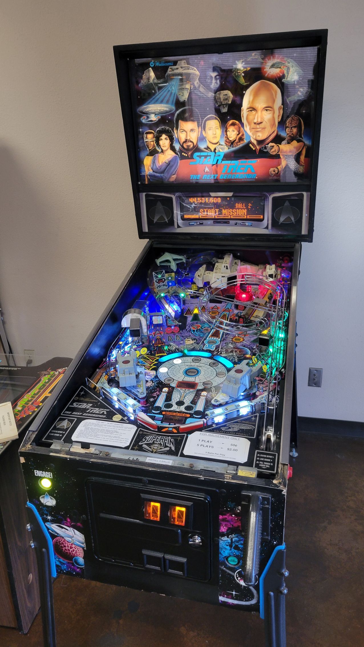 A pinball machine is sitting on a table in a room.