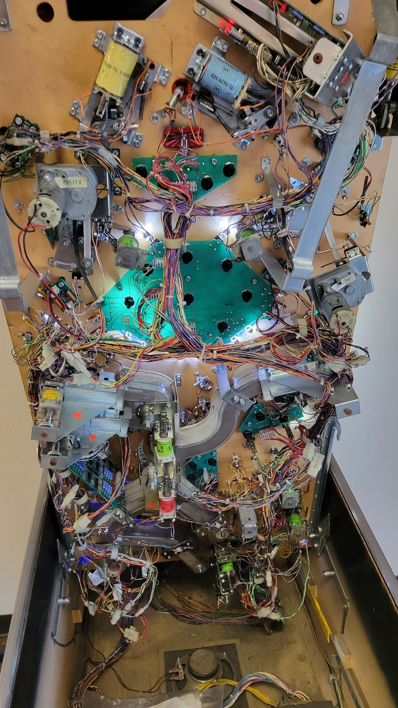 A pinball machine with a lot of wires coming out of it.