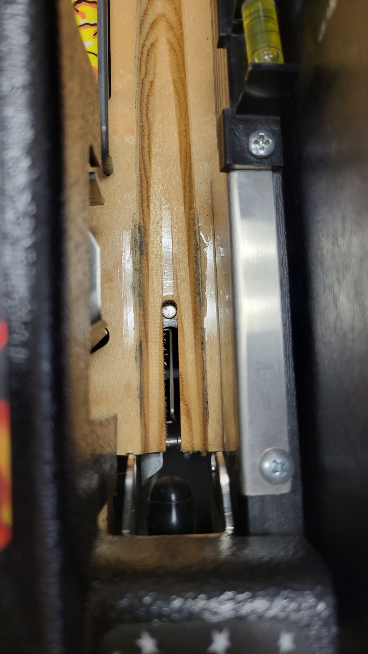 A close up of a machine that is cutting a piece of wood.