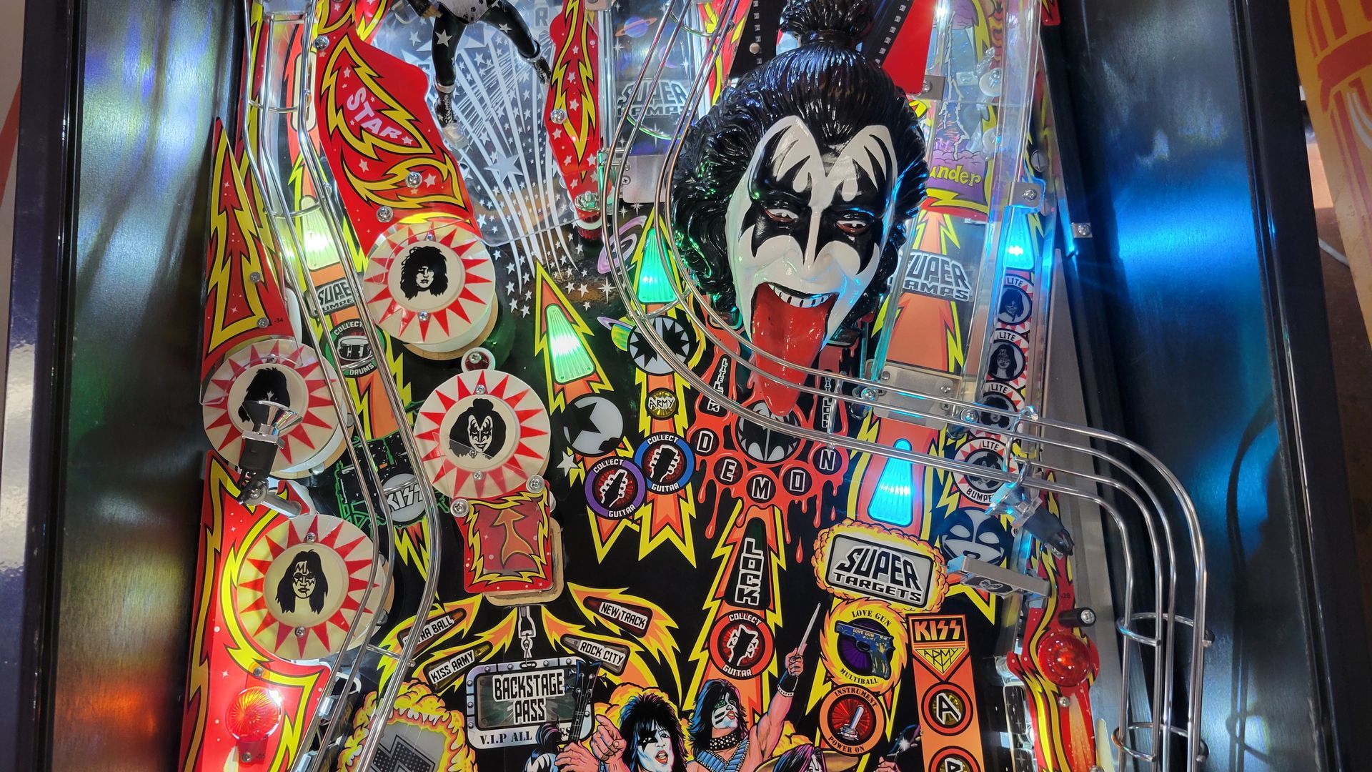 A kiss pinball machine is sitting on a table.