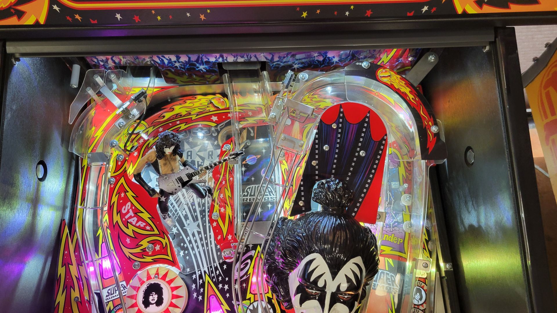 A kiss pinball machine is being played in an arcade.