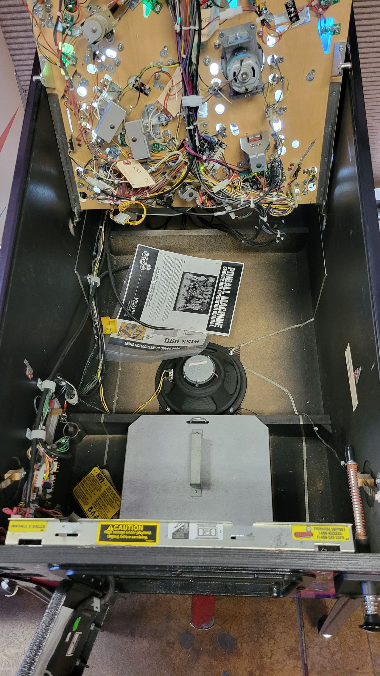 The inside of a pinball machine with a lot of wires coming out of it.