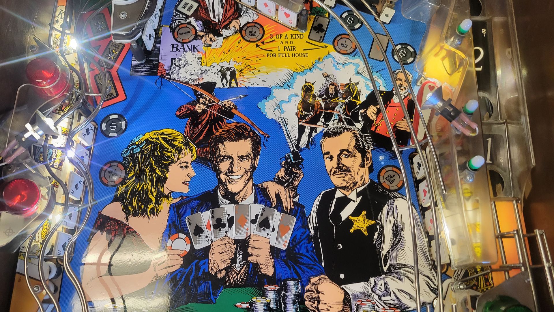 A pinball machine has a picture of a man and woman playing cards
