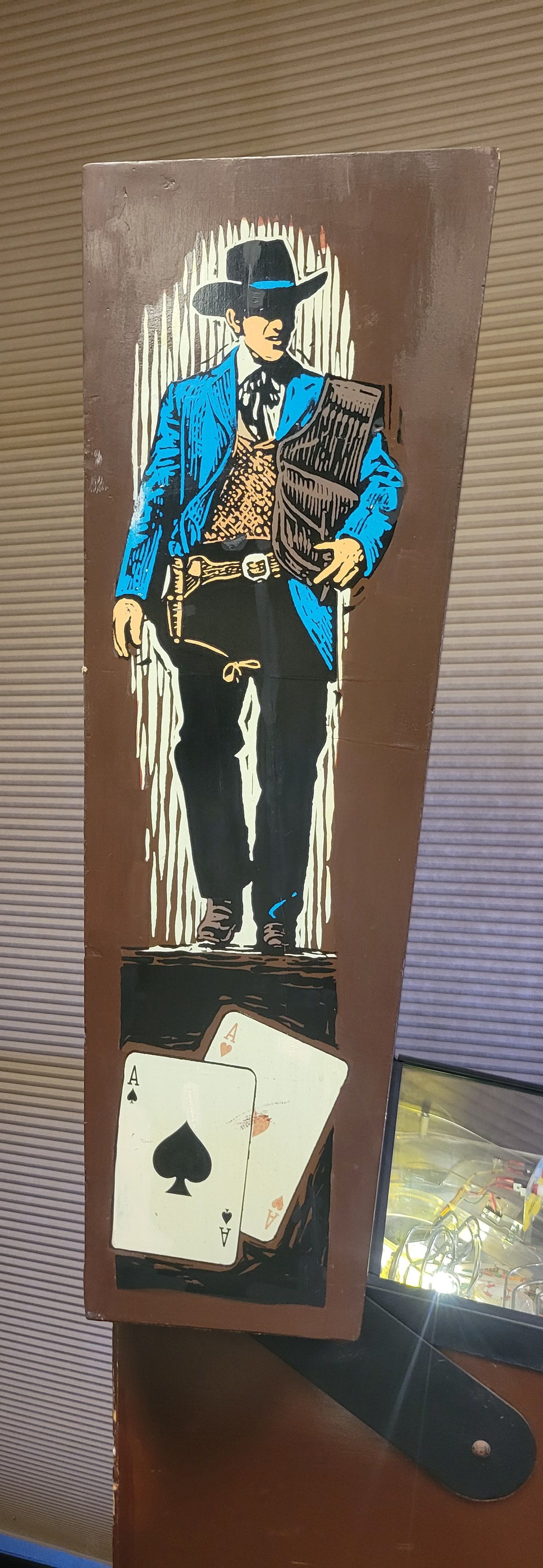 A painting of a cowboy standing on top of a pair of playing cards.
