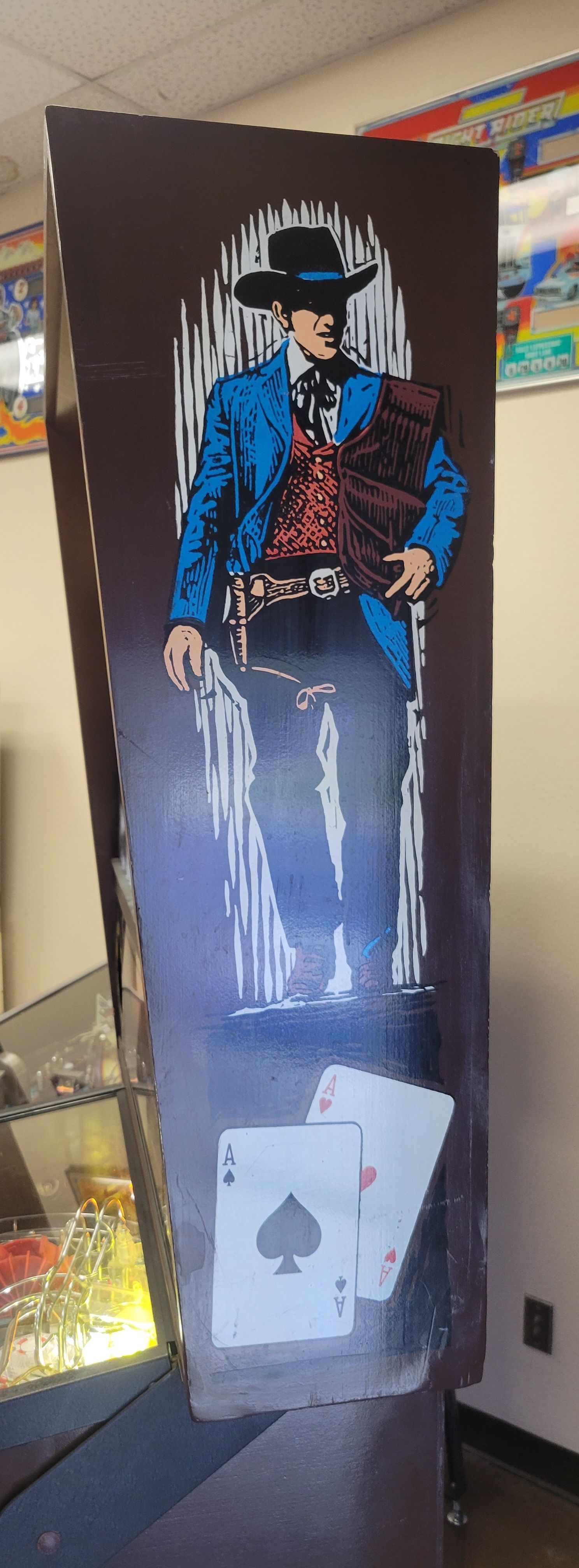 A man in a blue suit is standing next to a pair of playing cards.