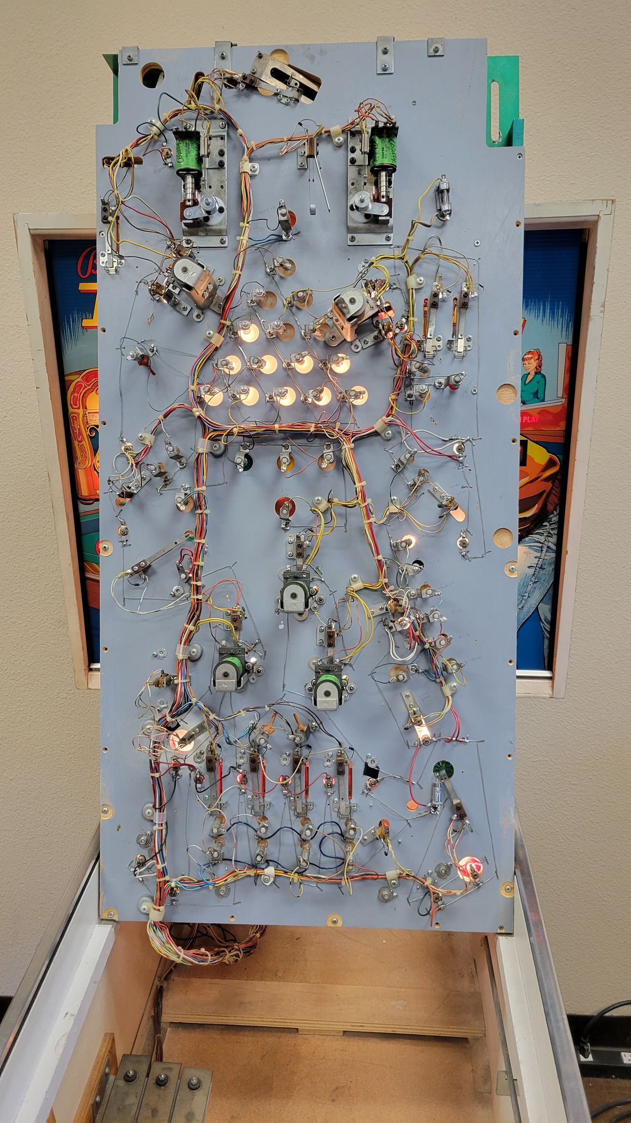A pinball machine with a lot of wires coming out of it.