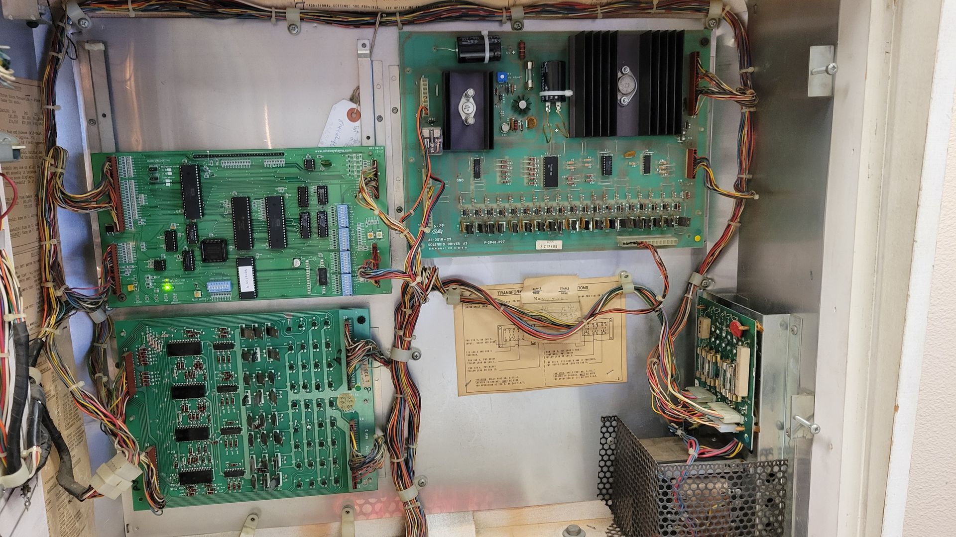 A bunch of electronic components are sitting inside of a metal box.
