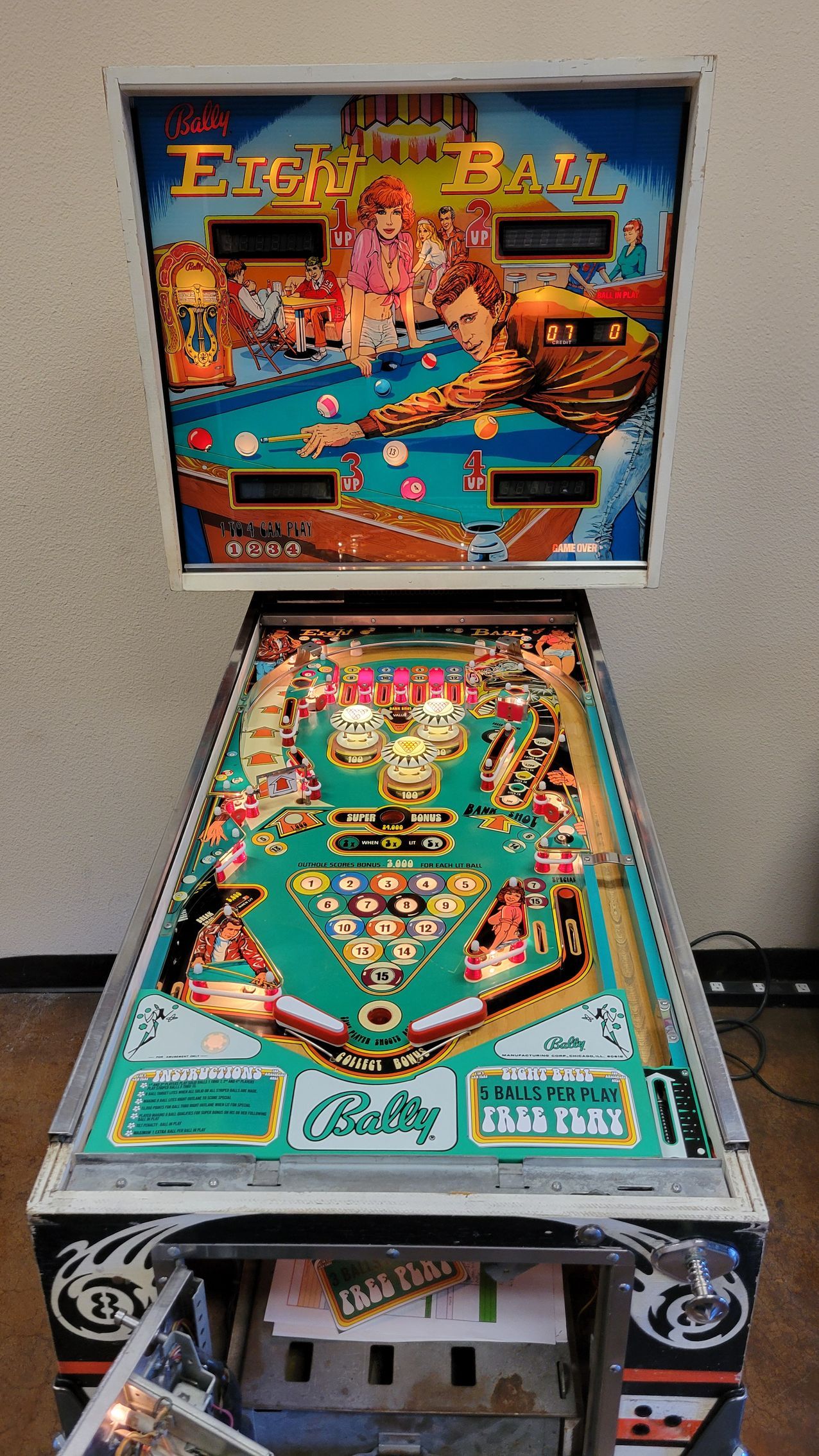 A pinball machine is sitting on a wooden floor.