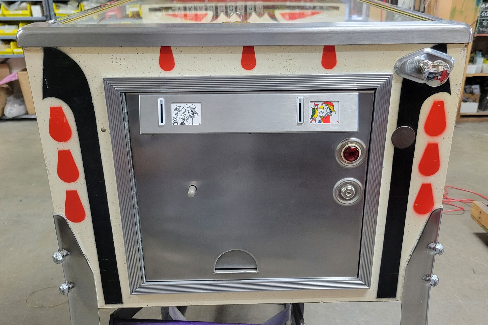 A pinball machine is sitting on a cart in a store.