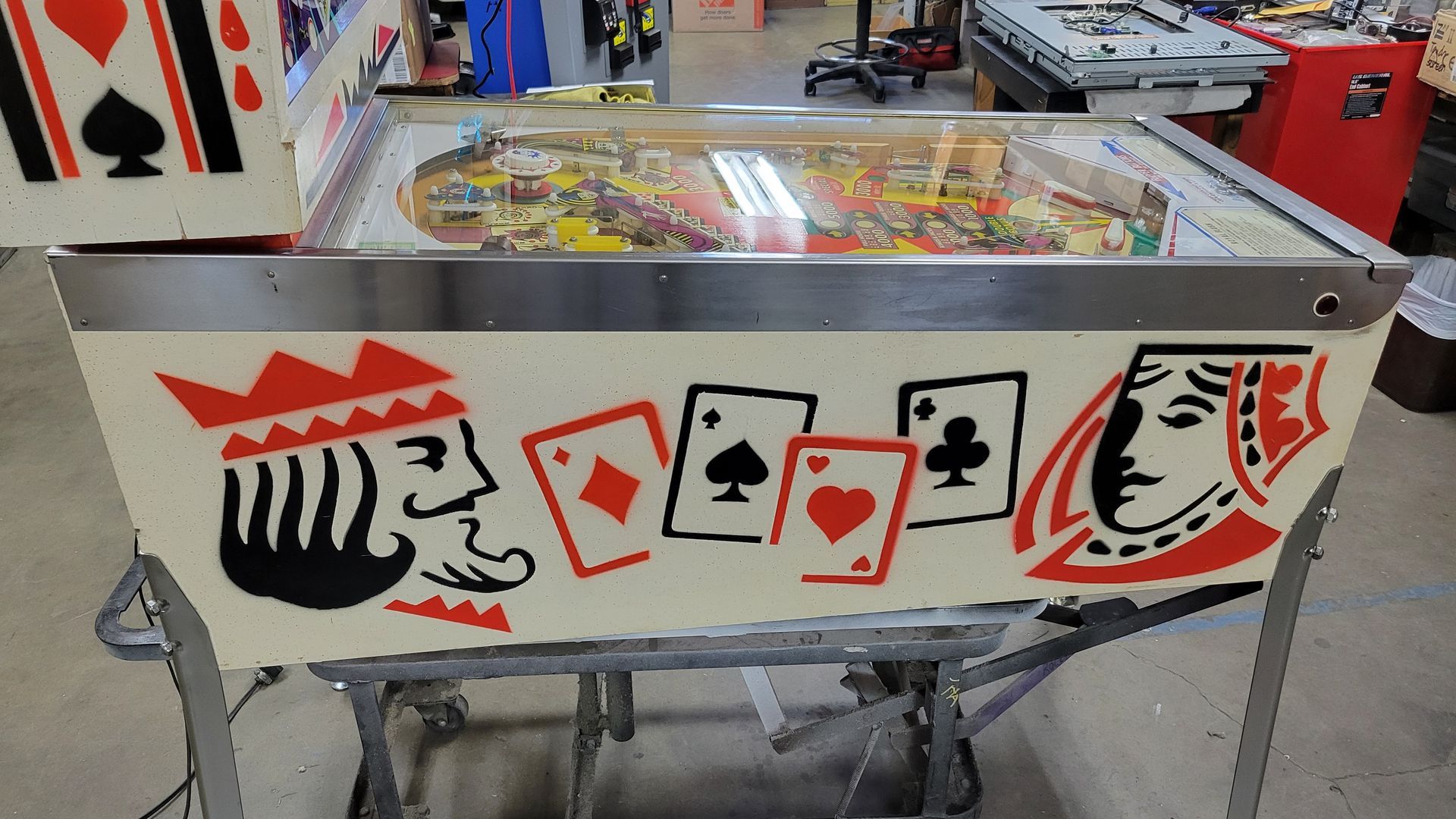 A pinball machine with playing cards on it