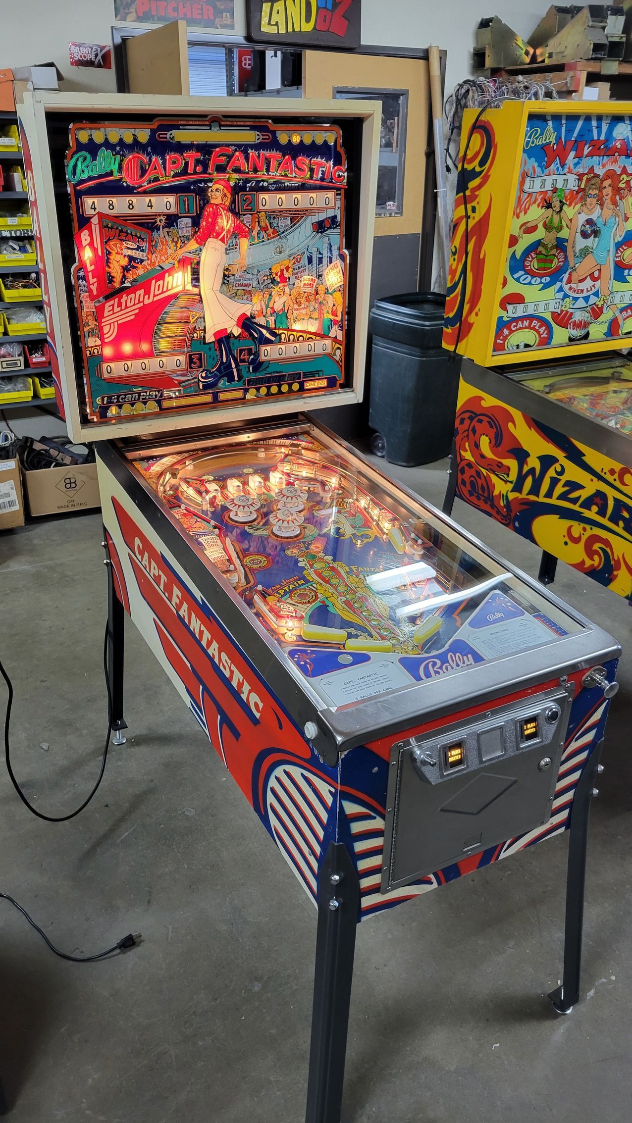 A pinball machine is sitting in a room next to other pinball machines.