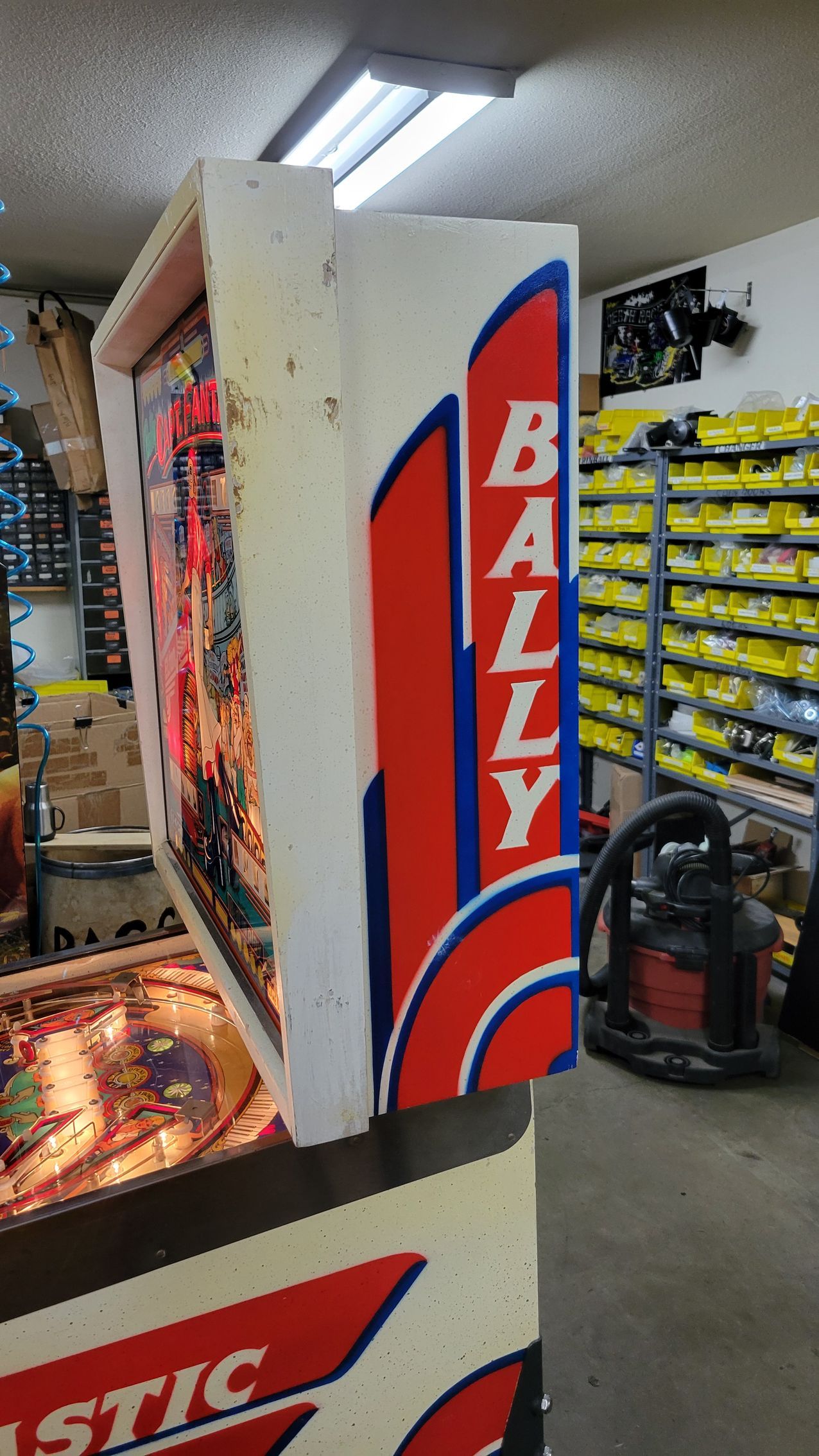 A bally pinball machine is being repaired in a garage