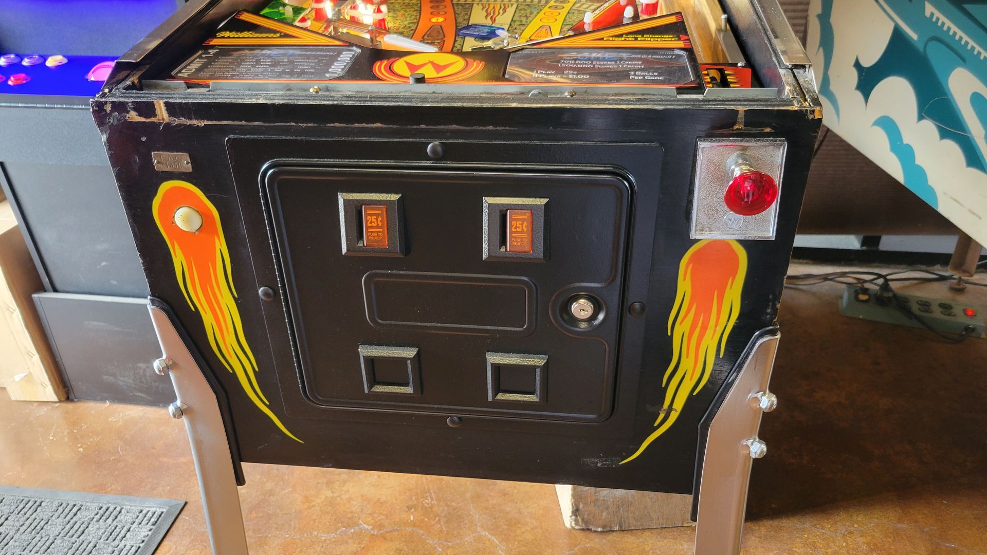 A pinball machine with flames painted on it