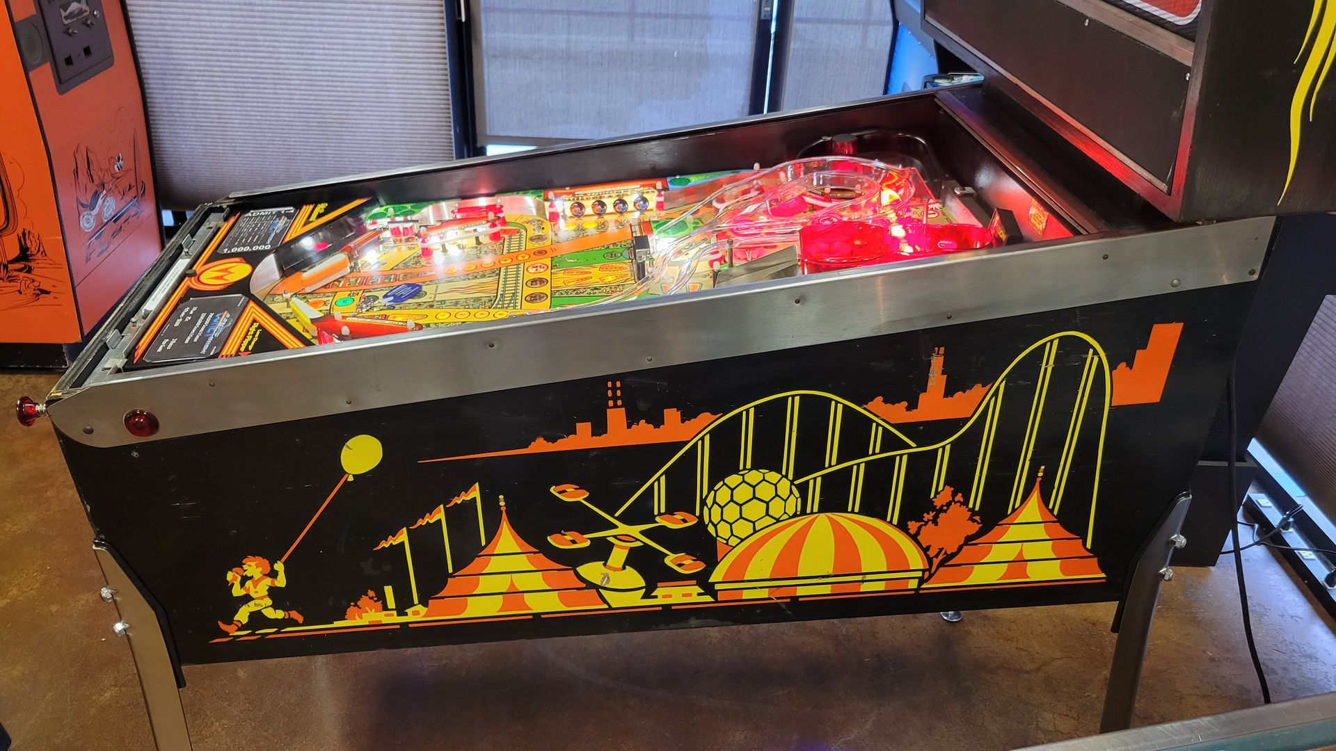 A pinball machine with a roller coaster on it