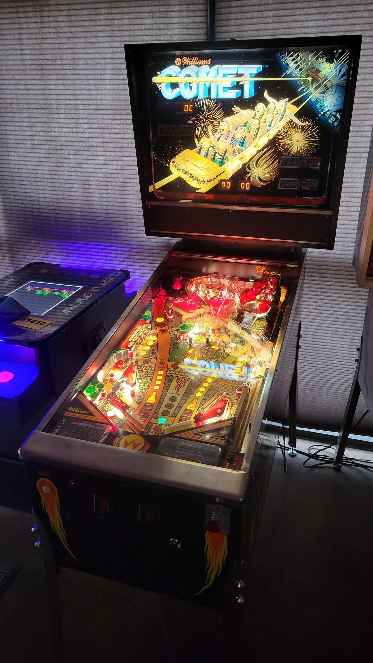 A pinball machine is sitting on a table in a room.