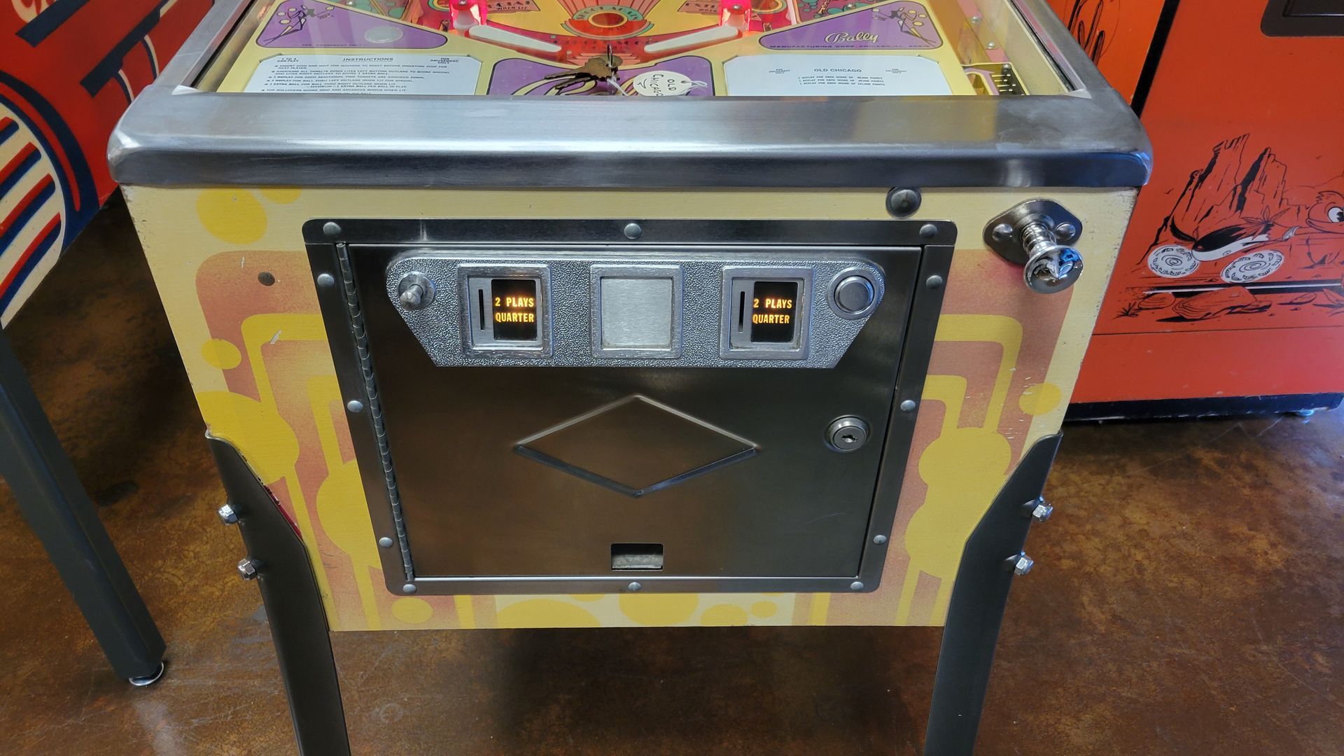 A pinball machine is sitting on a wooden floor.